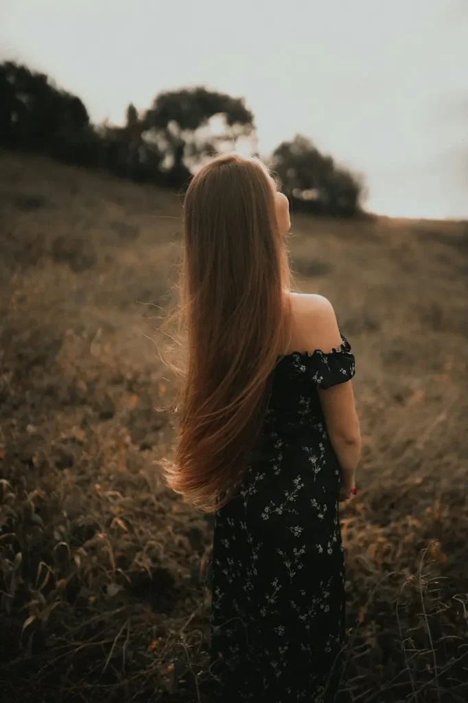 Hårolie til tørt hår – kvinde påfører olie i længder og spidser